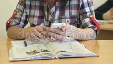 坐在办公桌前的女学生在笔记本上写课文