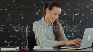 快乐女商人在笔记本电脑上工作