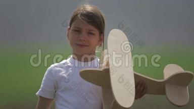 白人男孩玩<strong>模型飞机</strong>。 一个在田野里坐木<strong>飞机</strong>的孩子的肖像。