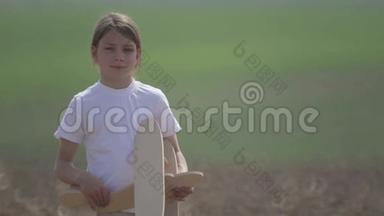 白人男孩玩<strong>模型飞机</strong>。 一个在田野里坐木<strong>飞机</strong>的孩子的肖像。