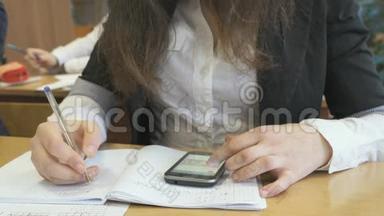 坐在办公桌前的女孩在笔记本上写课文