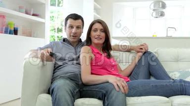 西班牙夫妇一<strong>起坐</strong>在沙发上看电视