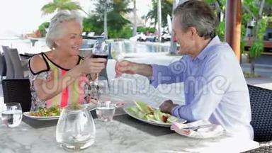 高级夫妇在户外餐厅享用美食