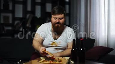 有胡子的胖子在电视机<strong>前端</strong>着啤酒和爆米花坐在桌子旁吃披萨
