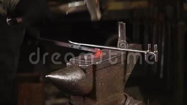 铁匠在锻铁的铁砧上敲打加热的金属坯
