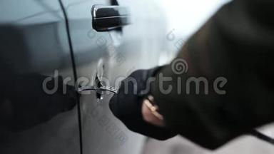 戴黑色皮革手套的人拿着金属棒在车门上打了个大洞。