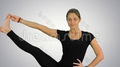 一个平衡和伸展的瑜伽姿势，女人在白色背景下练习