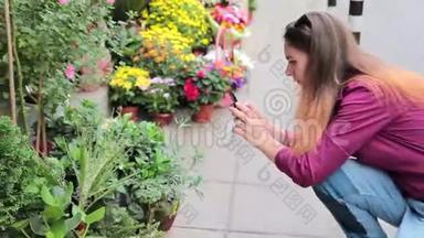 在欧洲街头的一家小花店里，一位年轻女子正在为鲜花拍照