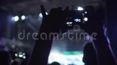 乐迷在音乐音乐会上拍摄视频，欣赏喜爱的乐队表演