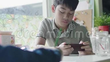 男孩在<strong>家</strong>里和朋友一起用<strong>数码</strong>平板电脑学习。