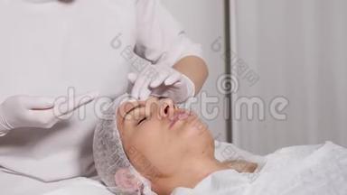 医生美容师给躺在特殊桌子上的病人卸妆