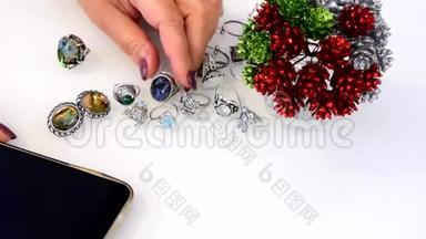 女人触摸由贵金属、<strong>贱</strong>金属、玻璃和智能手机制成的珠宝