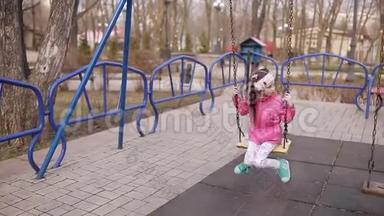 公园里的春游。 操场上的小女孩骑着秋千