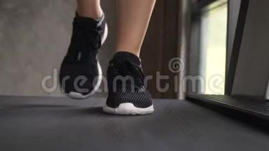 年轻女子在健身房跑步机上慢跑，脚踝感觉疼痛。 正面向上看