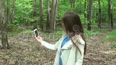 女孩在公园夏天拍自拍照片智能手机。 噗嗤笑了.. 视频拍摄<strong>运动摄像机</strong>..