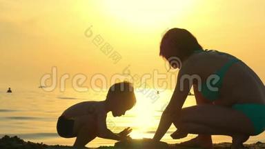 母子在沙滩上玩耍.. 妈妈和孩子在<strong>大海</strong>的<strong>背景</strong>下建造一座沙堡