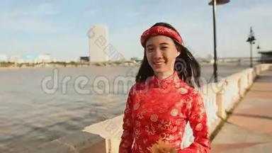 穿着民族服装的亚洲女孩和穿着越南傣族服装沿着河堤岘港散步
