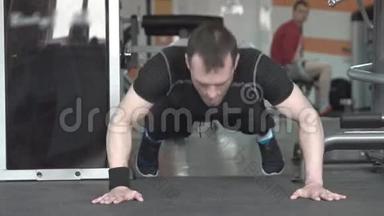健身员在健身房做拍手俯卧撑运动。