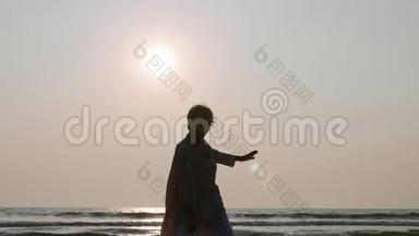 日落时分，一位资深女士在海滩上练习太极气球