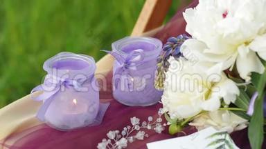 紫色婚礼装饰仪式。 有燃烧蜡烛的烛台。 婚礼花环和羽扇豆花束