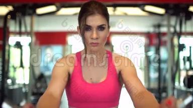 肌肉发达的女运动员穿着粉红色上衣在健身房<strong>锻炼</strong>举<strong>重</strong>。 健身女孩在健身房<strong>锻炼</strong>。 这就是