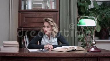 沮丧的女人不耐烦地看着桌子上的文件和书籍，砰地一声拳头砸在桌子上