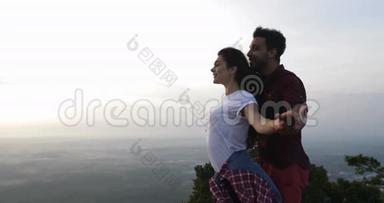 两人在山顶拥抱举起双手，快乐的拉丁男女享受自由之风
