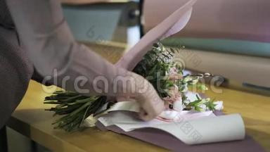 花匠把一束花绑在桌上的丝带上