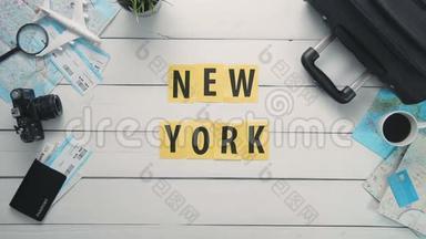 俯视图时间流逝的双手躺在白色的办公桌上`纽约装饰着<strong>旅行用品</strong>