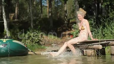 一个漂亮的女人坐在湖边的<strong>木墩</strong>上放松。