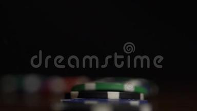 扑克筹码掉落。 扑克筹码站在黑色背景上，多米诺效应