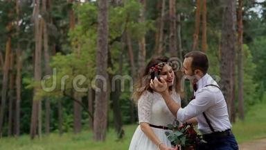 <strong>奢</strong>华幸福的新娘和时尚的新郎，坐在夏日森林的原木上.. 新郎<strong>轻轻</strong>抚摸新娘。