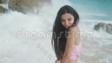 慢镜头，穿着<strong>泳装</strong>的快乐女孩的肖像，在<strong>海滩</strong>上放松，背景上有美丽的波浪，稳定的镜头。