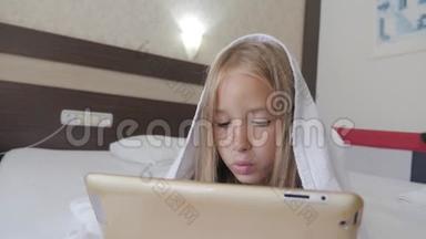 十几岁的<strong>女孩</strong>在床上玩<strong>社交网络</strong>上的平板电脑。 特写小<strong>女孩</strong>在数字平板上看视频..