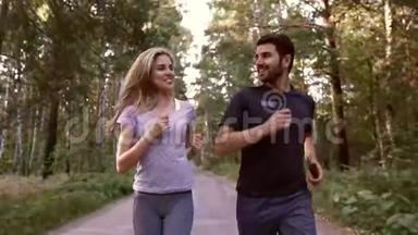 欢快的金发女人和英俊的男人一起在森林里慢跑的肖像