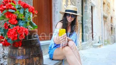 美丽的幸福女人在Cinque Terre欧洲度假时自拍。 年轻的高加索游客在自拍