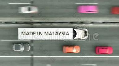 空中<strong>俯视</strong>的拖<strong>车</strong>卡<strong>车</strong>与MADE在马来西亚文字沿道路行驶。 马来西亚商务相关