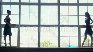芭蕾舞演员在芭蕾舞工作室的窗户上美丽的剪影。 一位蓝色芭蕾舞女演员
