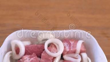 洋葱和香料腌制的生鱼片猪肉块。