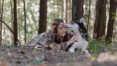 微笑的年轻女子躺在森林里，与她心爱的宠物有<strong>片刻</strong>的温柔
