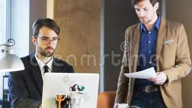 两个年轻的商人。 其中一个正在向他的搭档展示一份文件