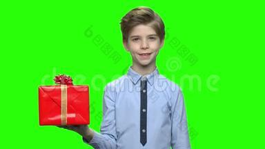 可爱的白种人小男孩拿着红色的礼盒。
