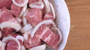 洋葱和香料腌制的生鱼片猪肉块。