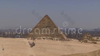骑骆驼的人步行到金字塔