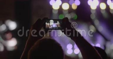 观众在<strong>室外</strong>音乐音乐会上用智能手机拍摄<strong>舞台</strong>全景照片