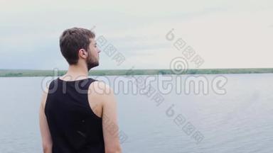 那个年轻人<strong>正向</strong>远处望着一个湖和一座山。 年轻人望着远处的湖