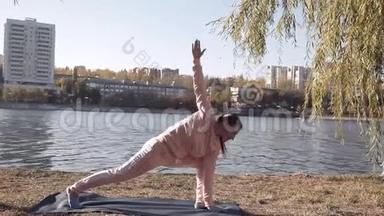 在公园里做瑜伽的女孩在河边
