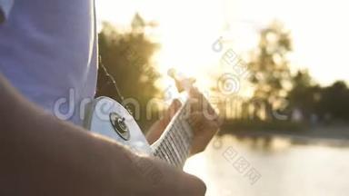 吉他手在户外、傍晚、日落时演奏电吉他和弦