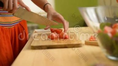 一个女孩的<strong>特写</strong>镜头切一张<strong>番茄</strong>木桌，用来做绿色<strong>番茄</strong>、柠檬和奶酪沙拉