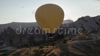 一个黄色的大气球的跨度，在一个人的篮子里，特写.. 飞越群山-卡帕多西亚全景